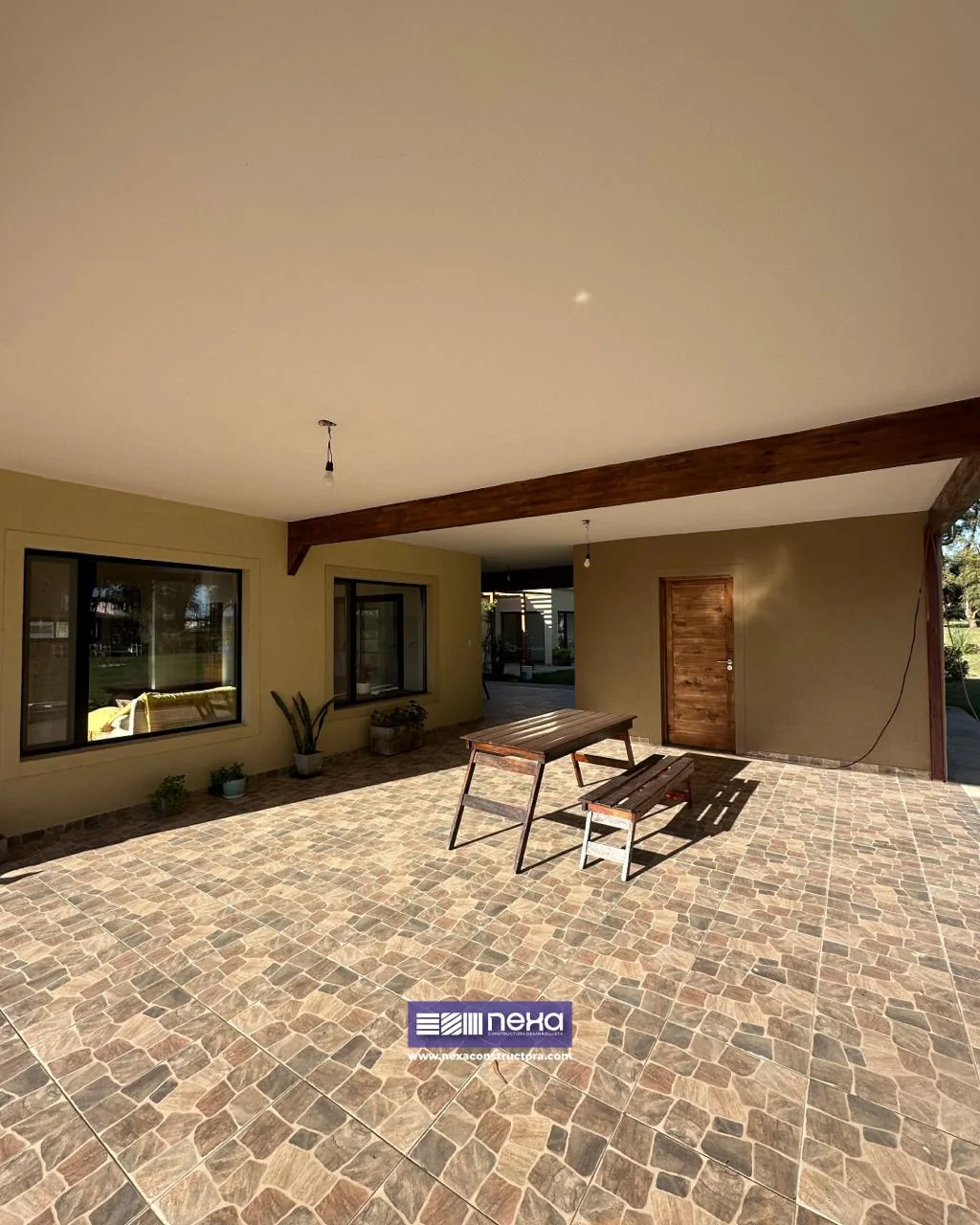 Chacras de San Andrés · Casa 1 — Galería cubierta con piso tipo adoquín, viga de madera y una mesa con banco