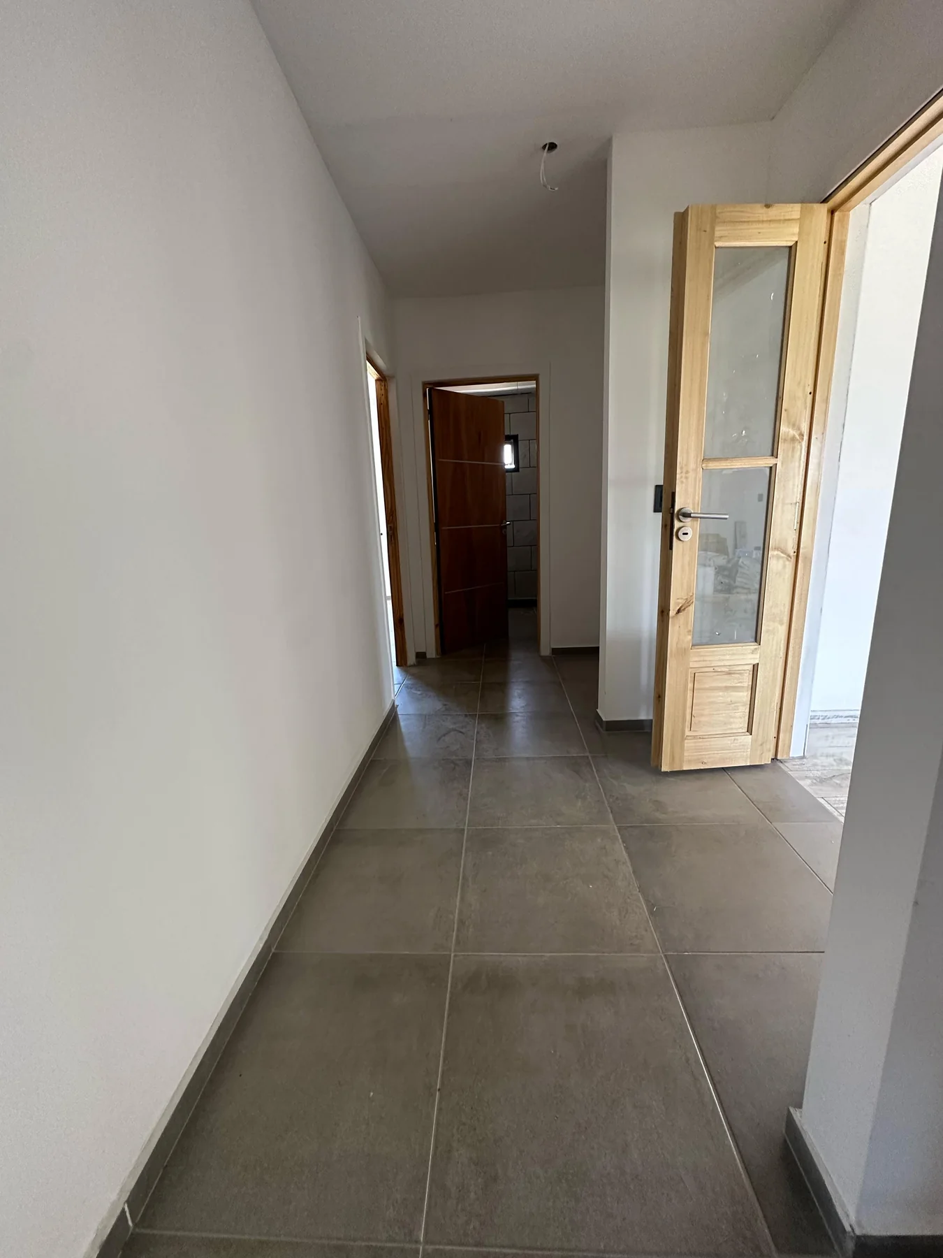 Chacras de San Andrés · Casa 2 — Pasillo con piso de porcelanato gris y puertas de madera
