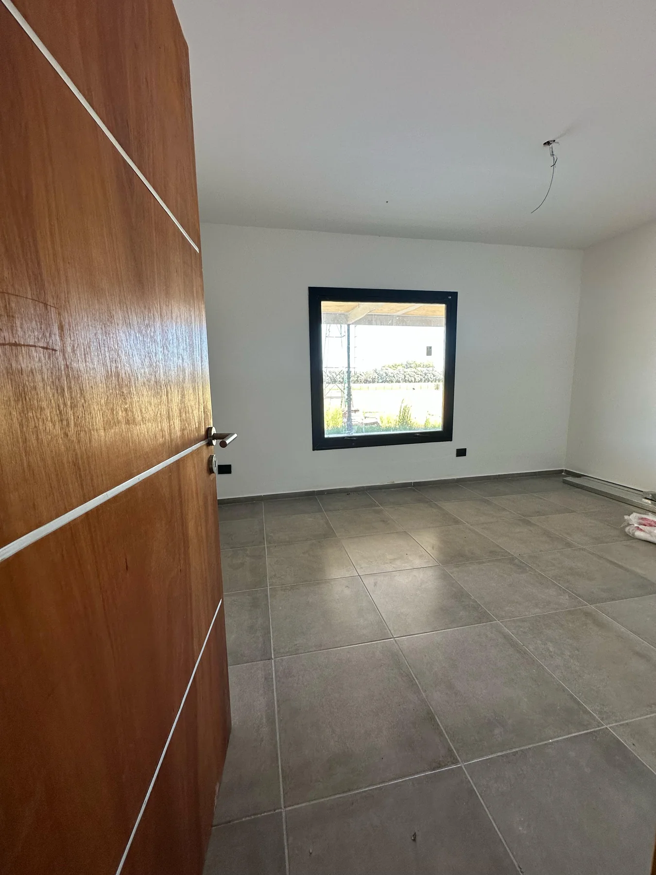 Chacras de San Andrés · Casa 2 — Otra habitación, con puerta placa de madera y ventana de marco negro