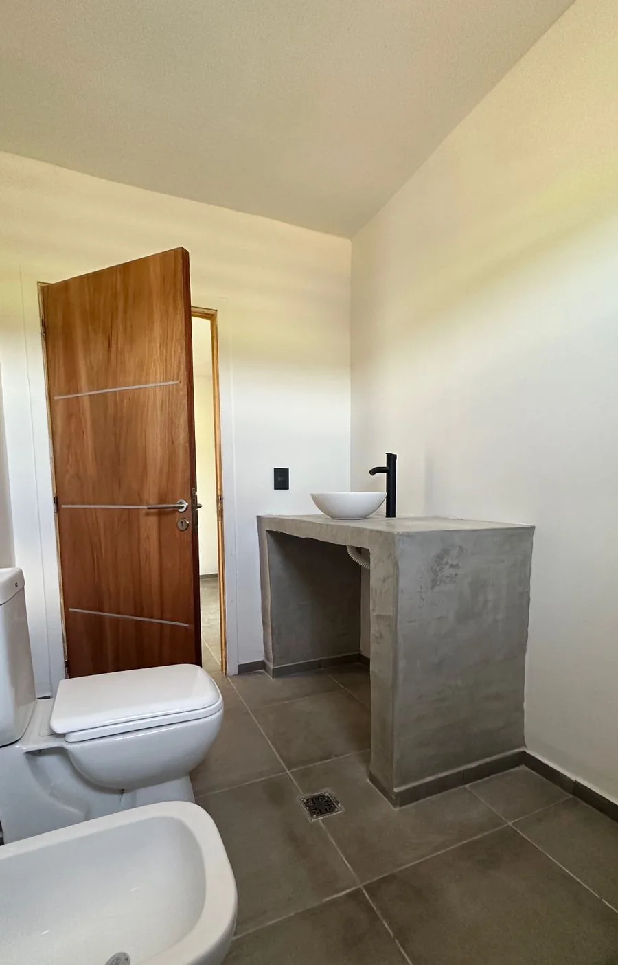 Chacras de San Andrés · Casa 2 — Baño con mesada gris de obra, bacha de apoyo blanca, inodoro y bidé