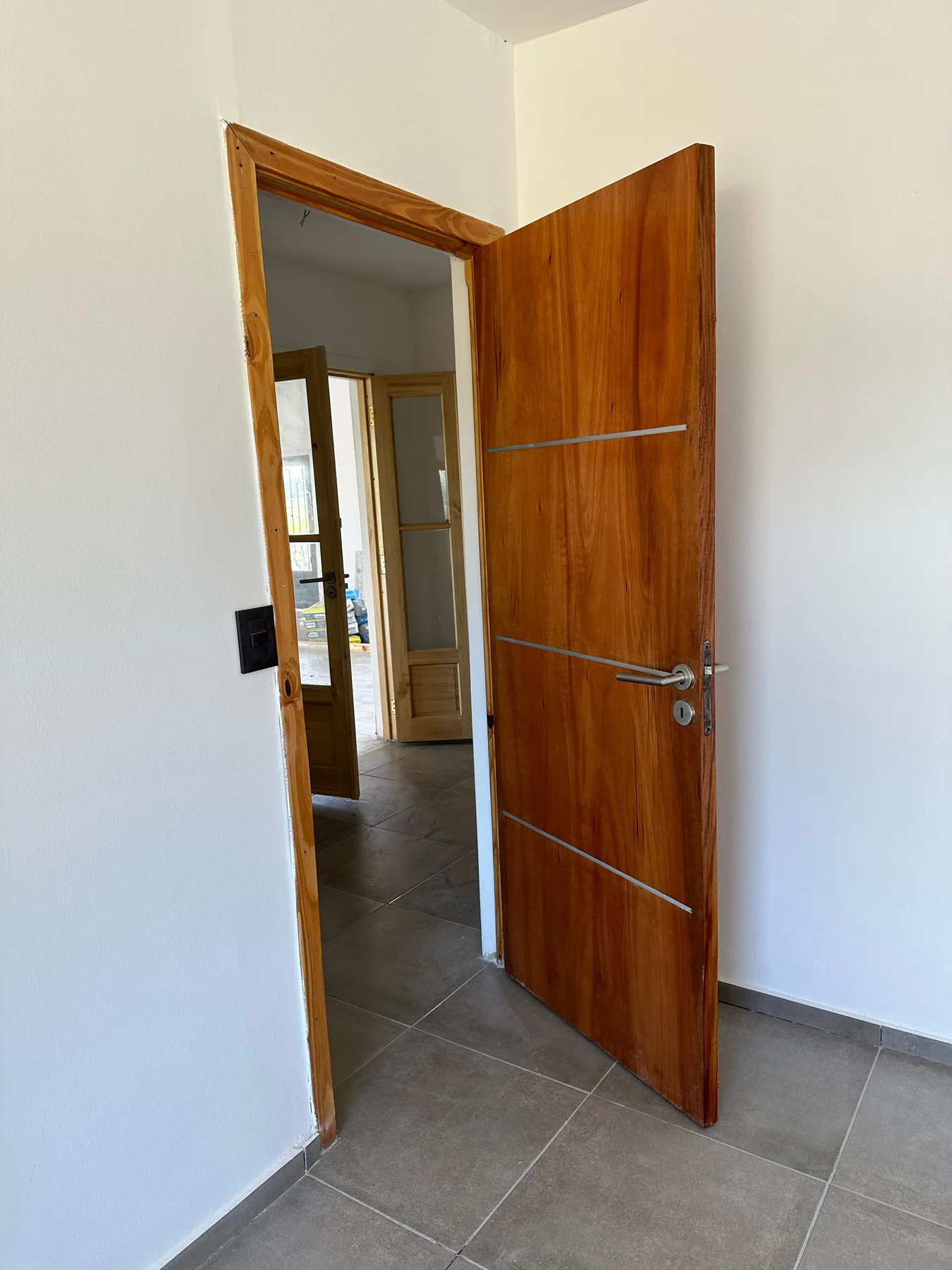 Chacras de San Andrés · Casa 2 — Puertas interiores: puerta placa con líneas metálicas y, detrás, una de madera vidriada