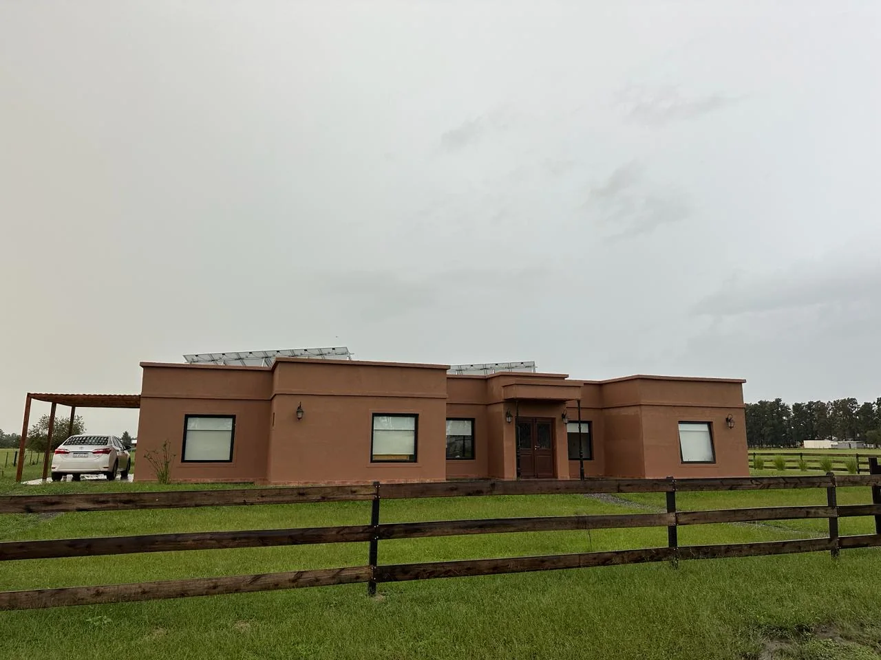 Chacras de San Andrés · Casa 3 — El frente, con el camino de piedra y el cerco de madera