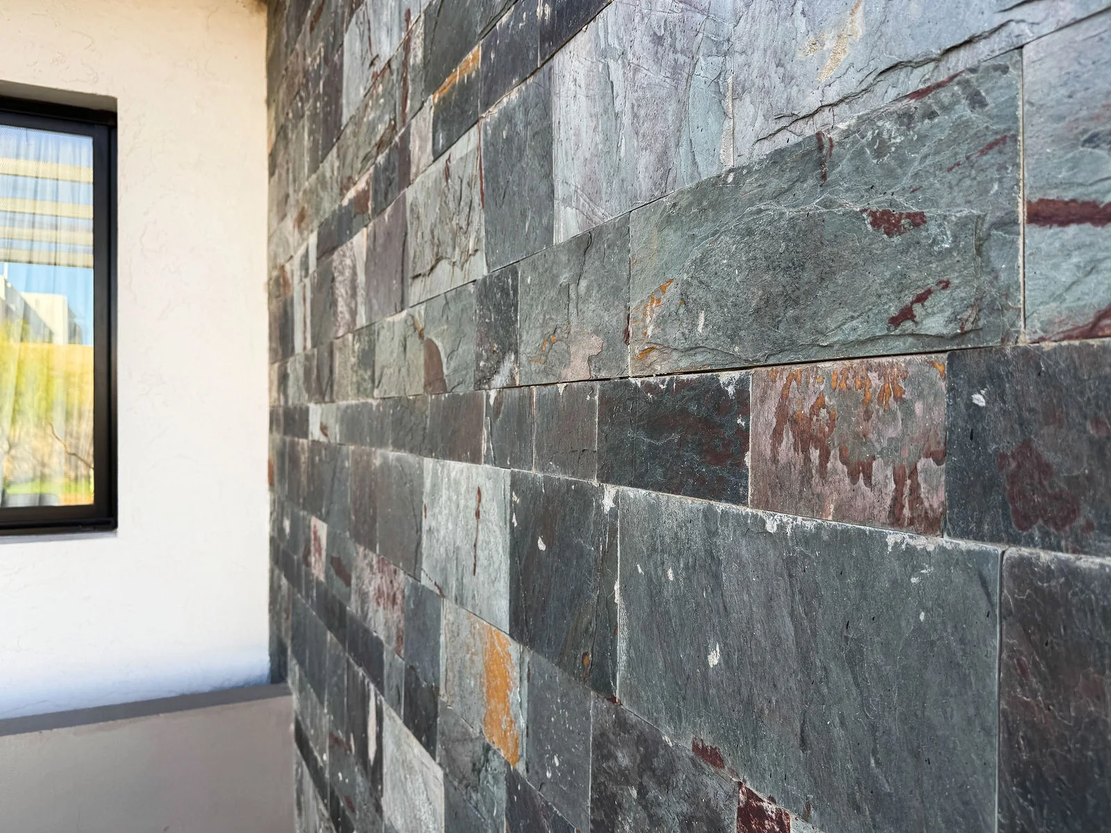 Docta — Detalle del revestimiento de piedra del frente, junto a una ventana