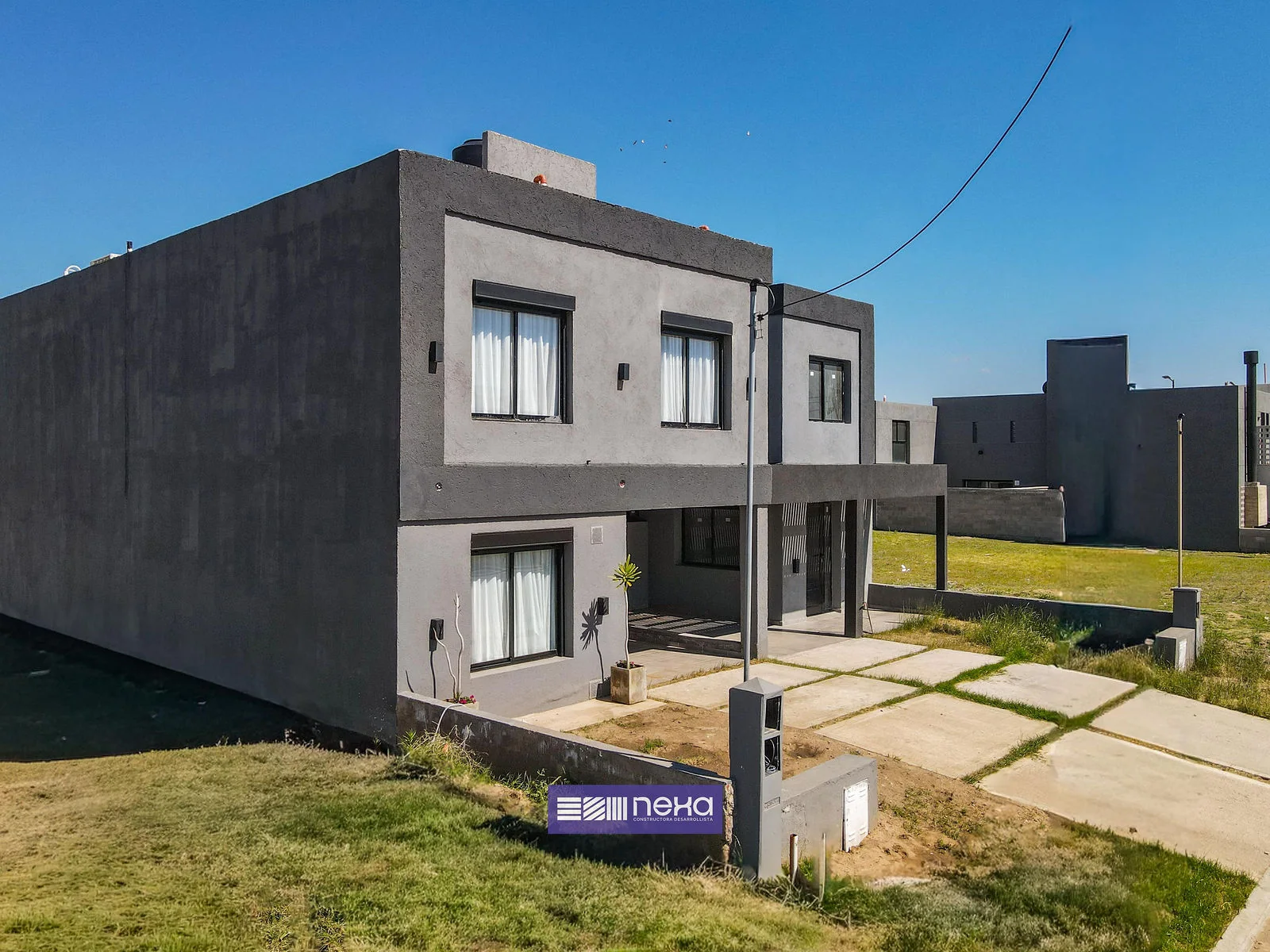 Rincones de Manantiales — El dúplex desde la esquina, con el lateral y el frente
