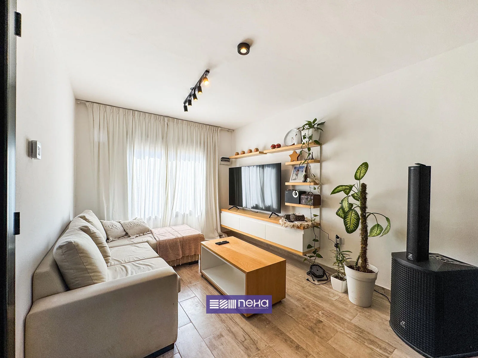 Rincones de Manantiales — Living con sillón en L, mueble de la tele y estantes con plantas