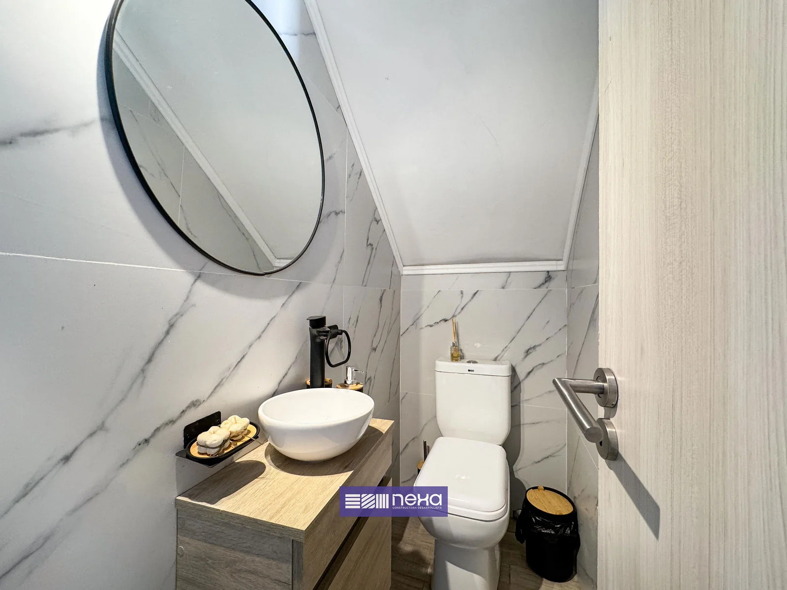 Rincones de Manantiales — Baño de cielorraso inclinado, con bacha de apoyo, inodoro y espejo redondo