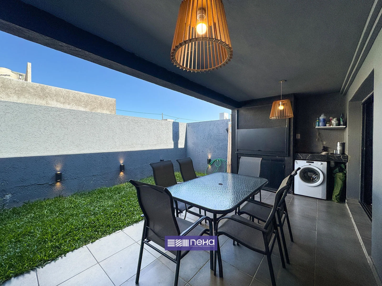 Rincones de Manantiales — La galería hacia el fondo, con la mesa de exterior y el lavarropas