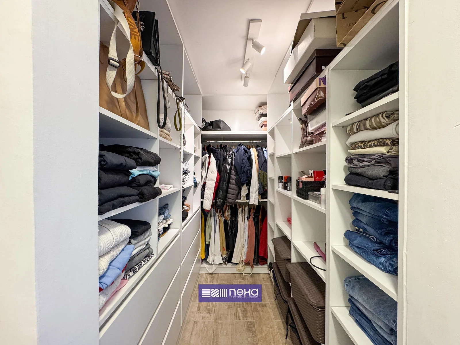 Rincones de Manantiales — Vestidor con estantes y ropa colgada