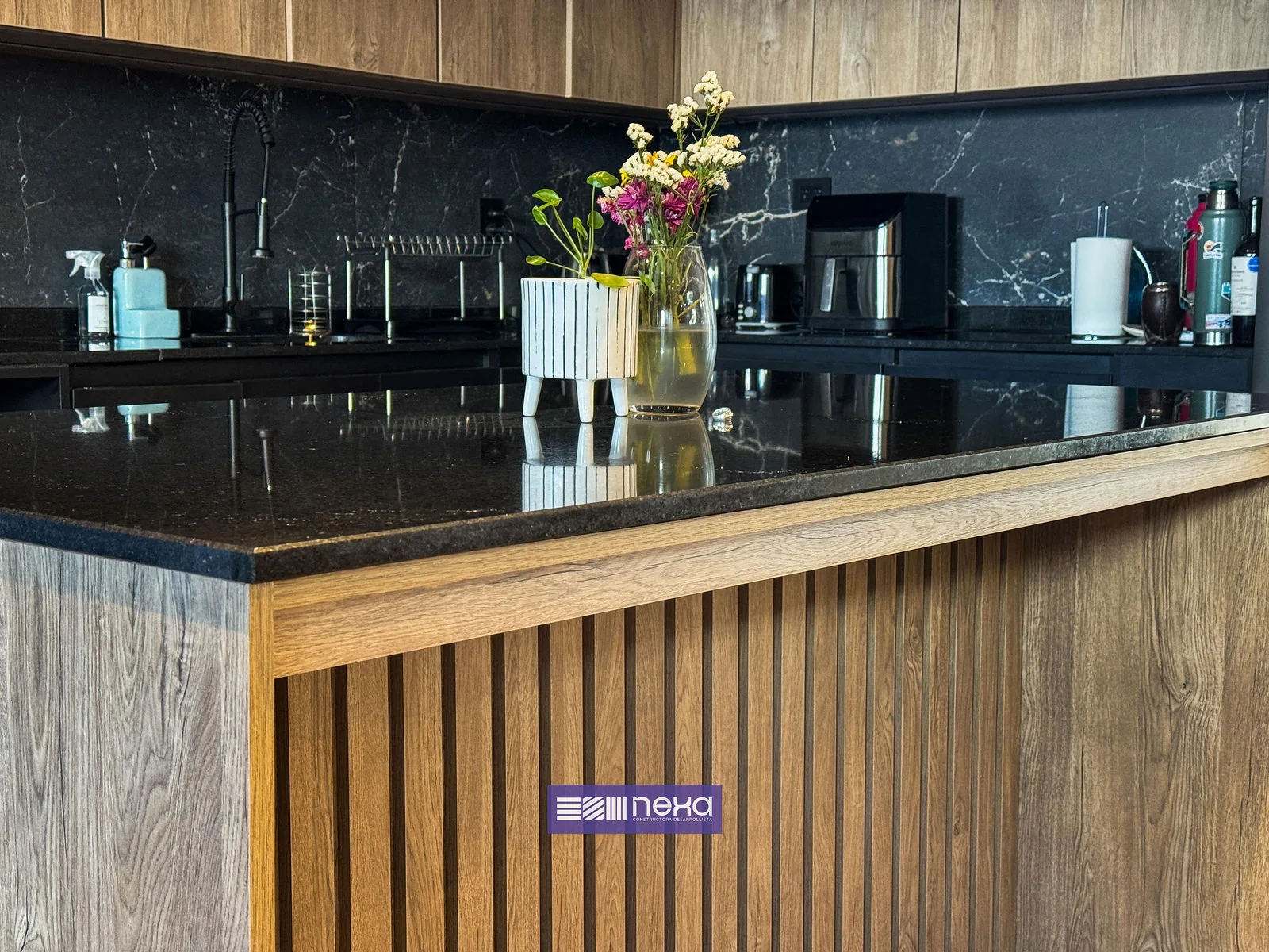 Rincones de Manantiales — Detalle de la isla: mesada oscura y frente de listones de madera