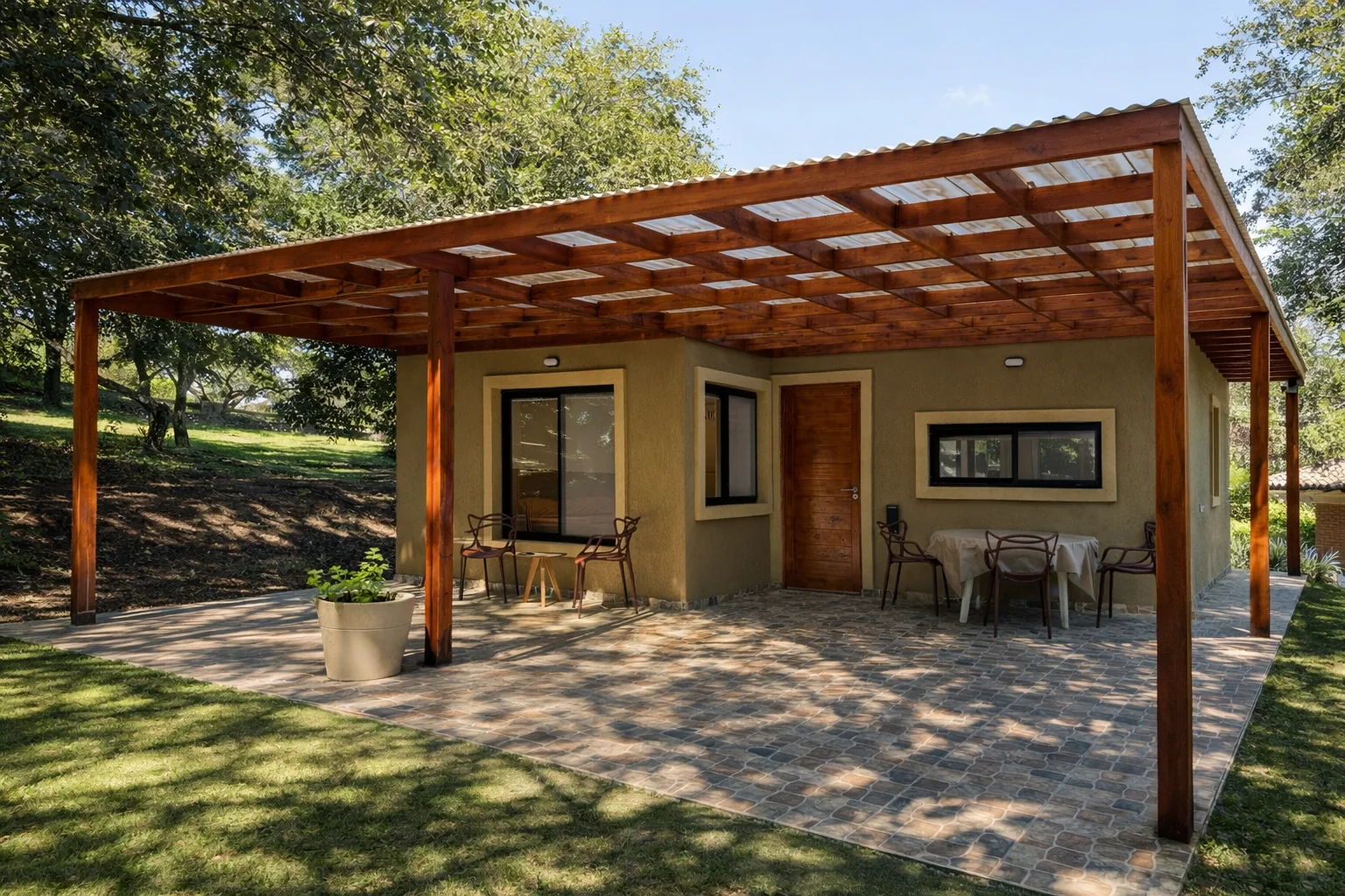 Complejo en La Granja — Una de las unidades bajo la pérgola de madera con techo translúcido, con la galería de piso de piedra, mesa y sillas