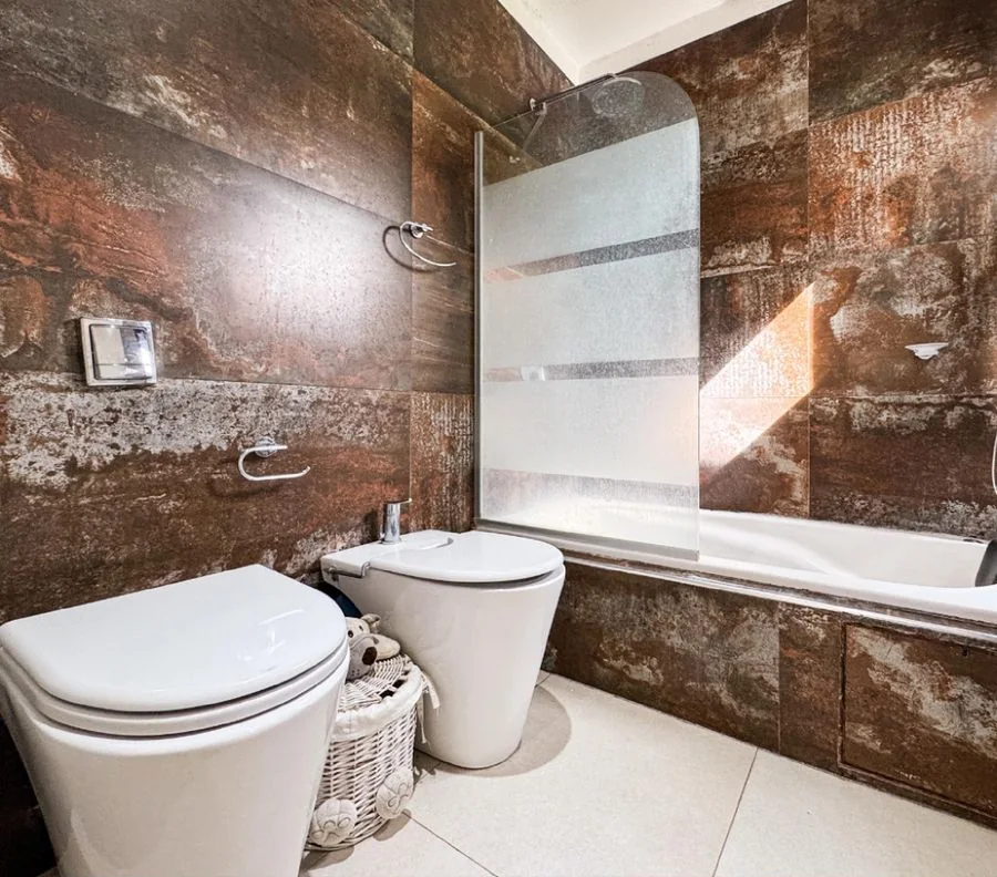 La Melinca Country Golf — Baño con hidromasaje, mampara y revestimiento símil óxido