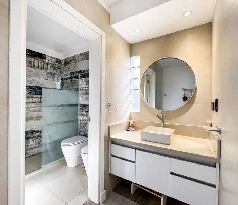 La Melinca Country Golf — Baño con vanitory blanco y espejo redondo; al fondo, la ducha