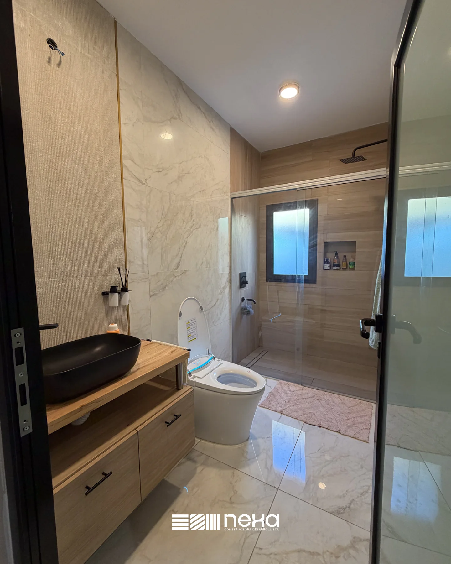 Los Olivos, Guaymallén — Baño con ducha de mampara, revestimiento símil mármol y vanitory de madera con bacha negra
