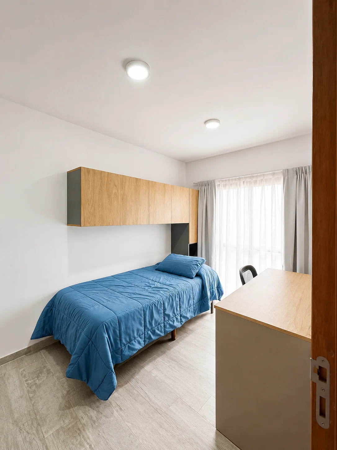 Tejas Cuatro — Dormitorio con cama de una plaza, escritorio y alacenas de madera