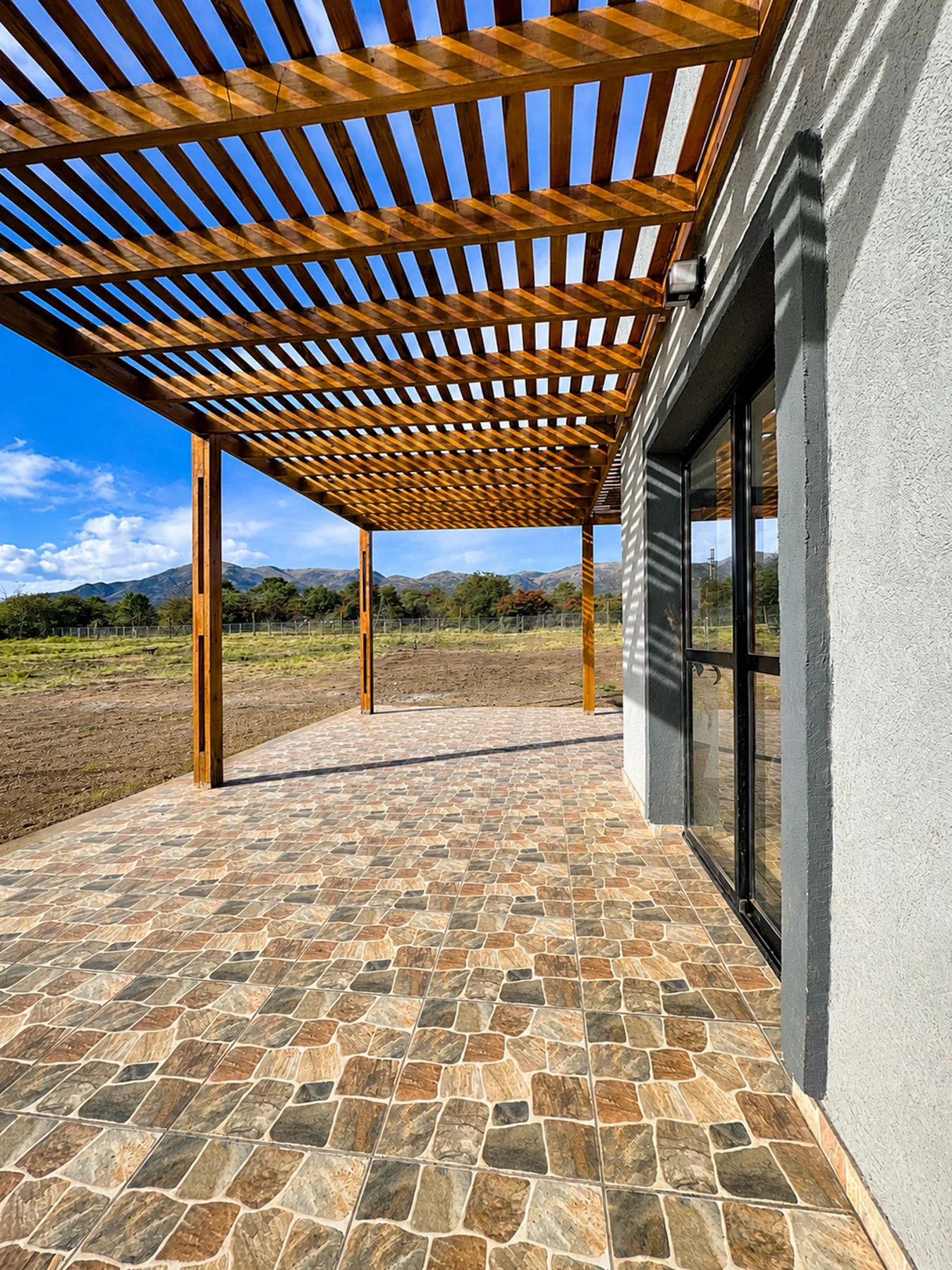 Villa Giardino — Galería bajo la pérgola de madera, junto a los ventanales