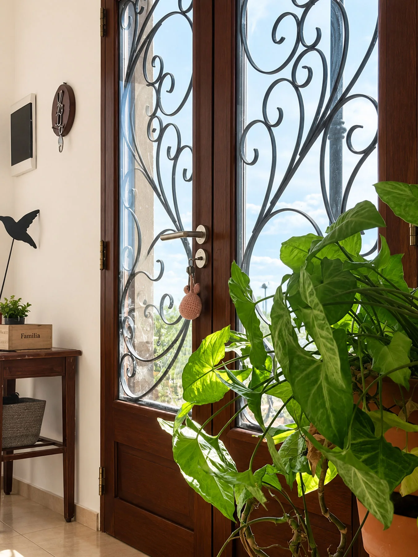 Villa Giardino — Puerta de entrada de madera con vidrio y herrería, vista desde adentro