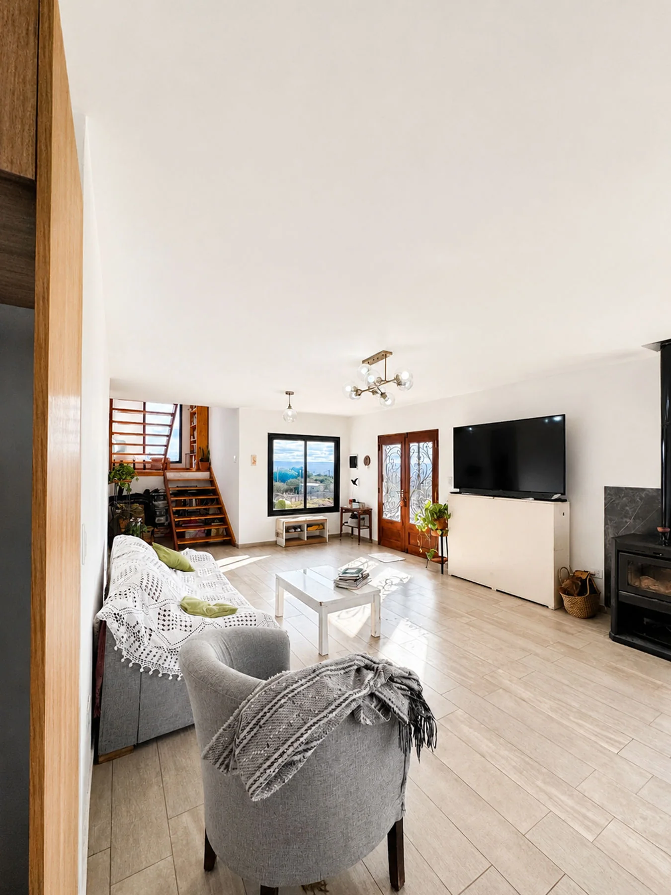 Villa Giardino — Living hacia la escalera, con el sillón y la tele