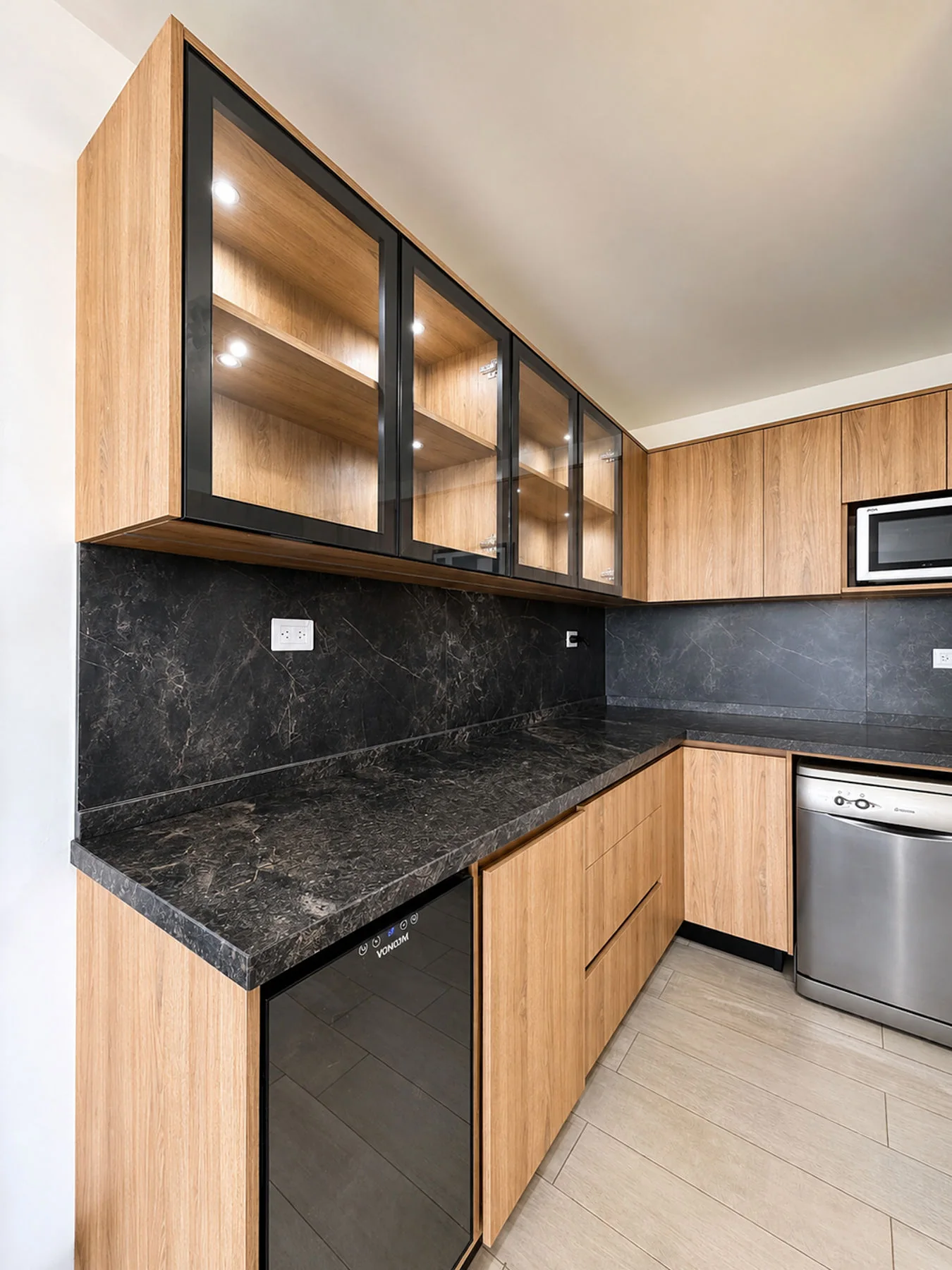 Villa Giardino — Alacenas con puertas de vidrio y marco negro sobre la mesada de piedra oscura