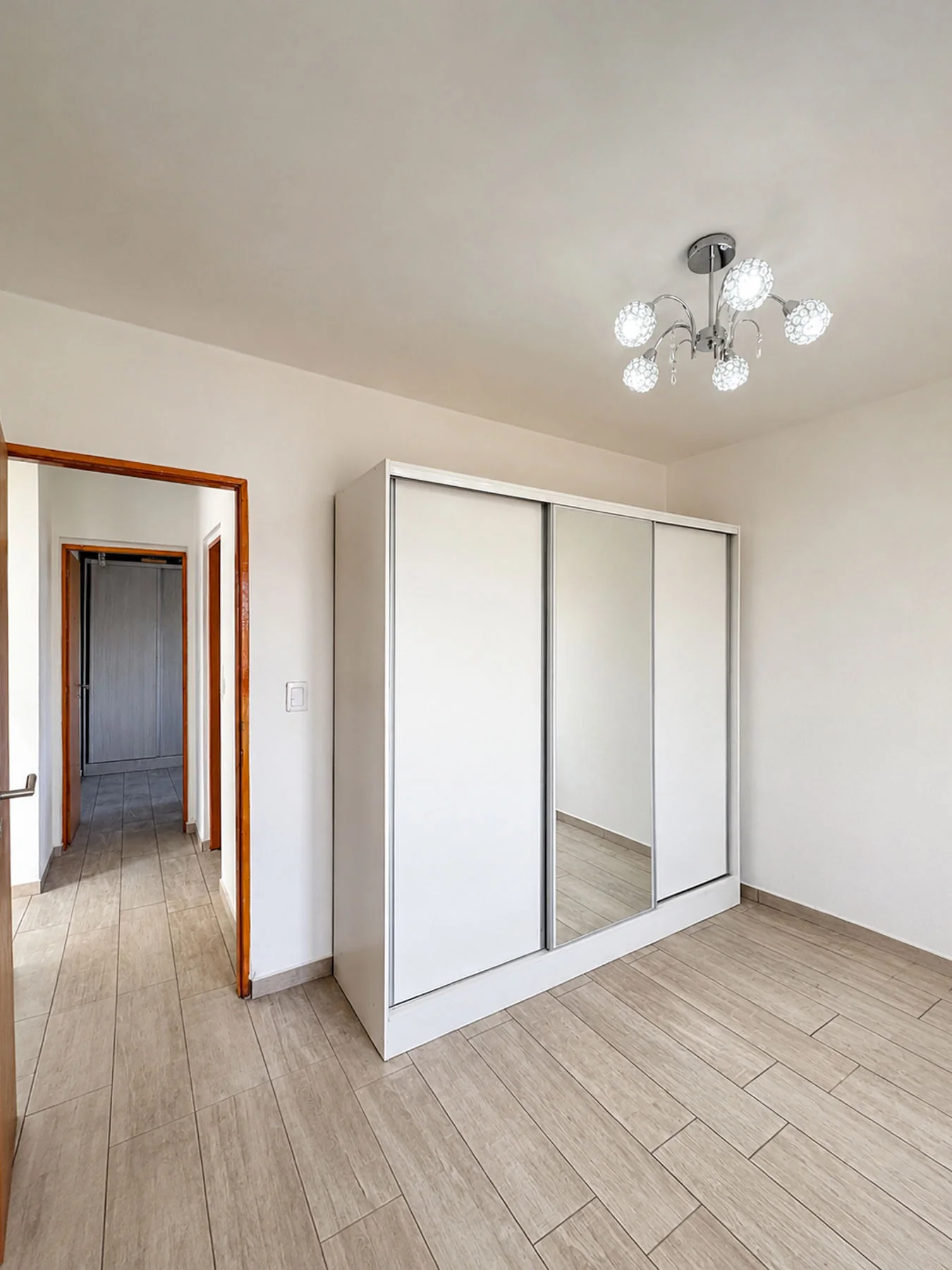 Villa Giardino — Dormitorio con placard blanco de puertas corredizas y espejo
