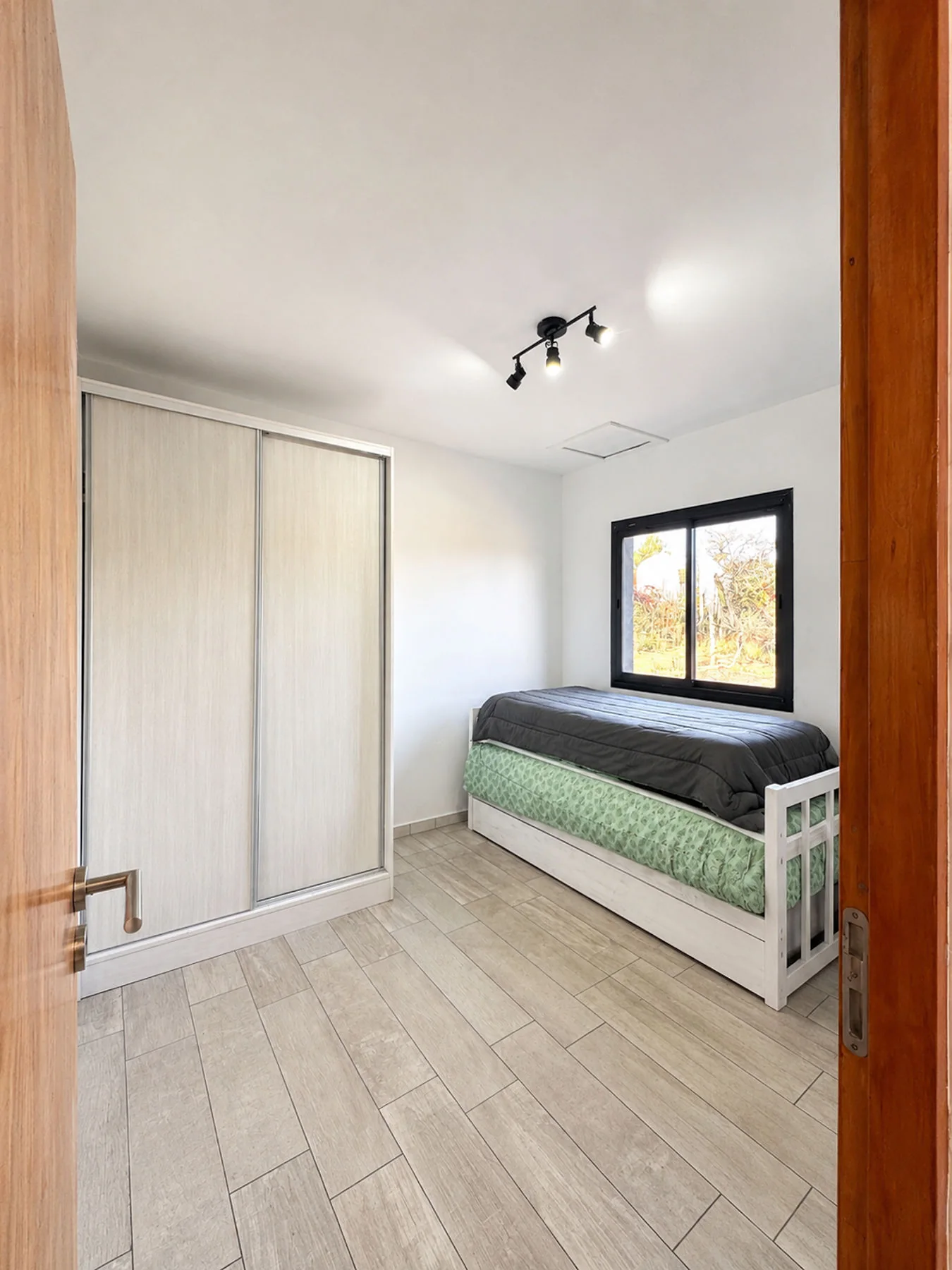 Villa Giardino — Dormitorio con cama de una plaza, cama nido y placard de madera clara