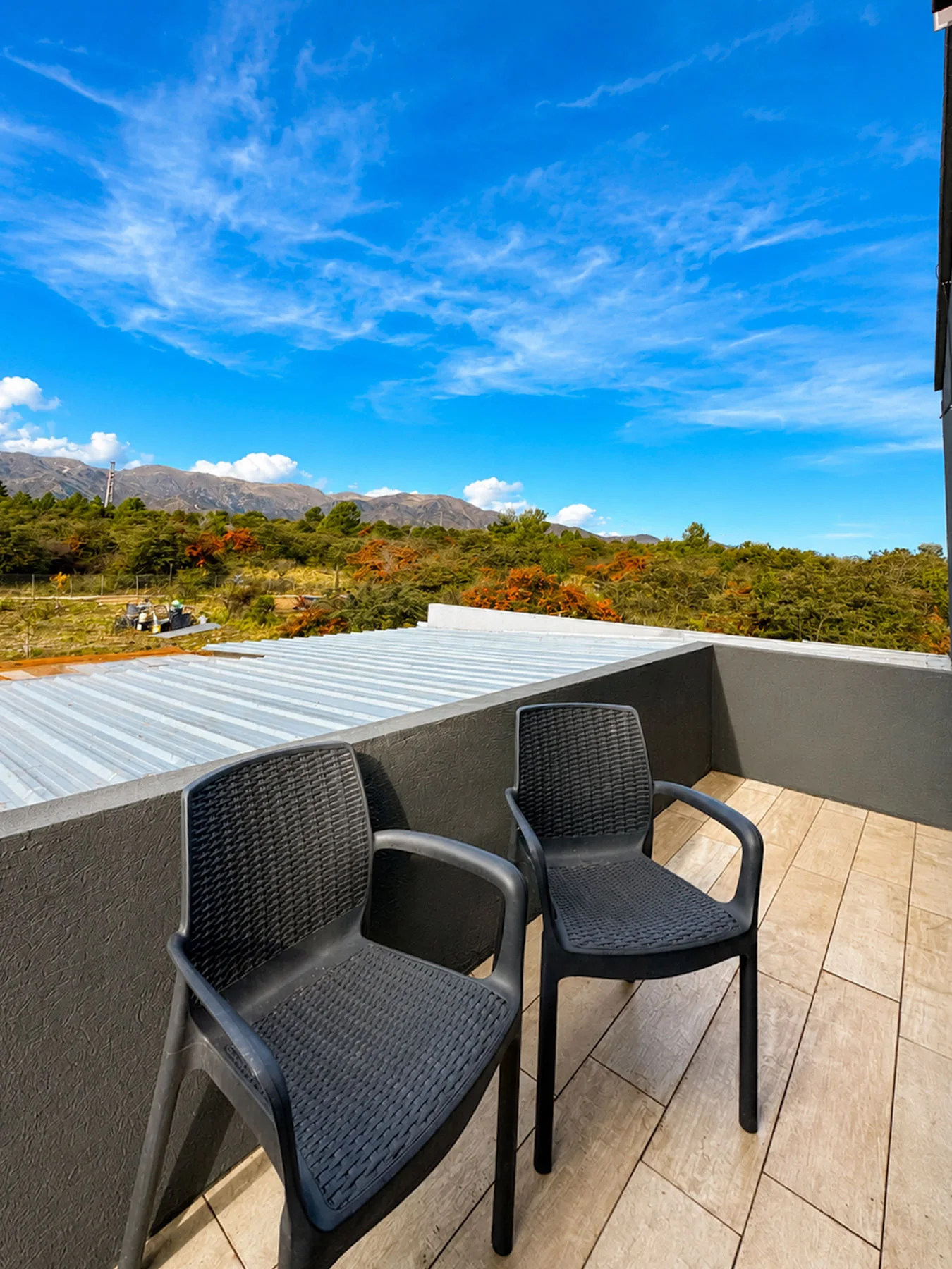 Villa Giardino — Terraza con dos sillas y vista a las sierras