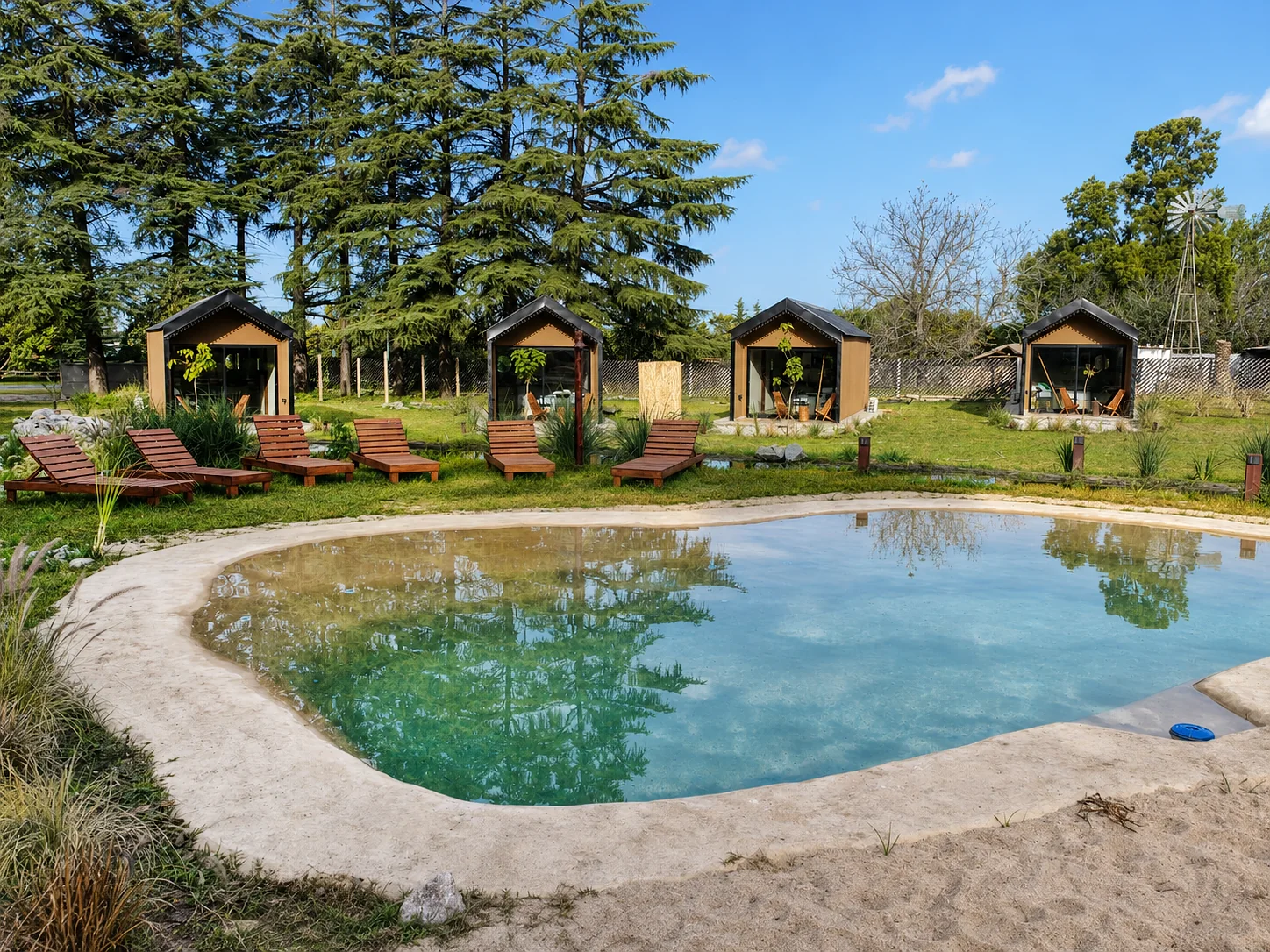 Villa Vadori · Suites Serranas — Las suites detrás de la pileta, con reposeras de madera