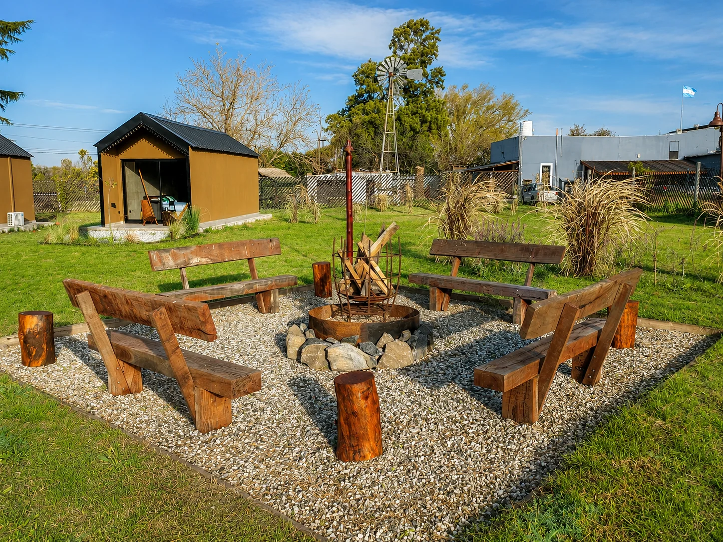Villa Vadori · Suites Serranas — Fogón con bancos de madera sobre piedra suelta