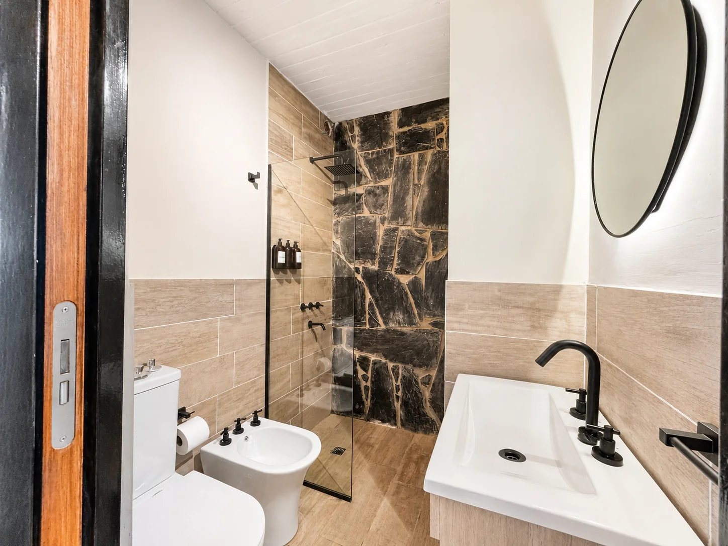 Villa Vadori · Suites Serranas — Baño completo de esa habitación: vanitory, inodoro, bidet y ducha con mampara