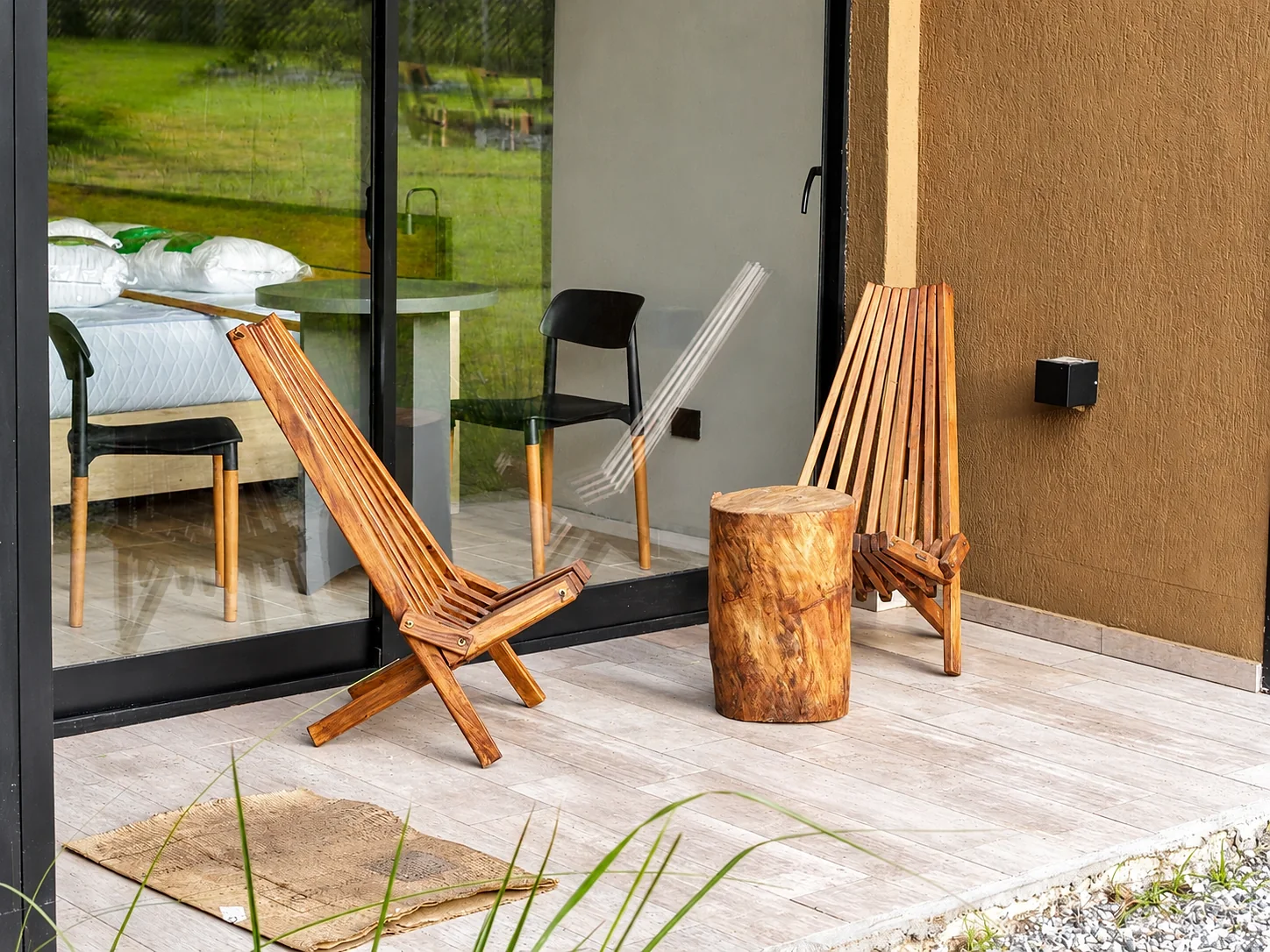 Villa Vadori · Suites Serranas — Deck de una suite con sillones de madera frente al ventanal, con la cama a la vista